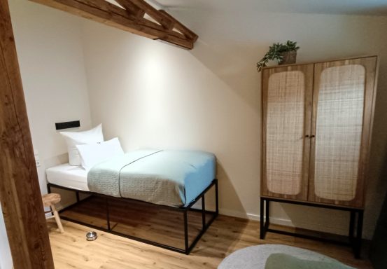 Schlafzimmer 2 Ein einfaches Schlafzimmer mit einem Hochbett und einem Kleiderschrank aus Holz.